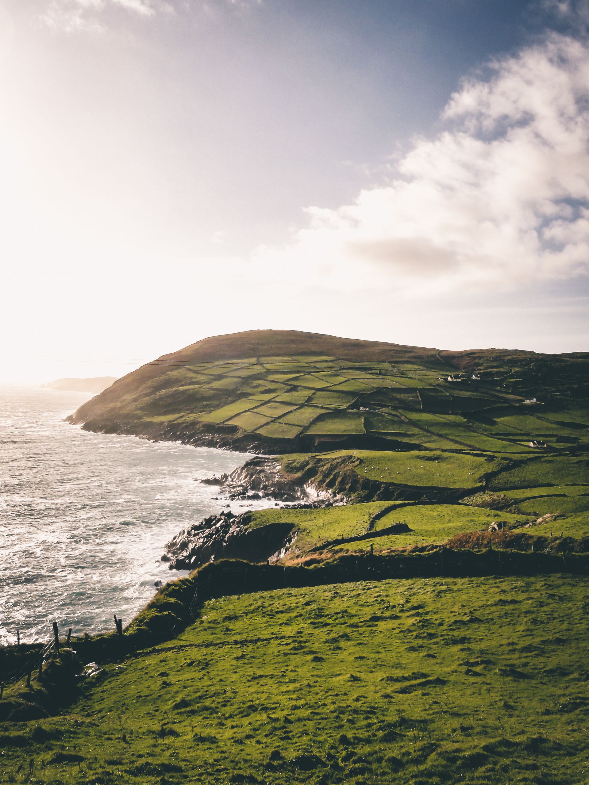 Green Irish hills running down to a headland and the Atlantic