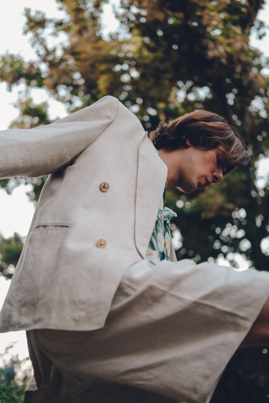 Man in a pale linen jacket among green leaves