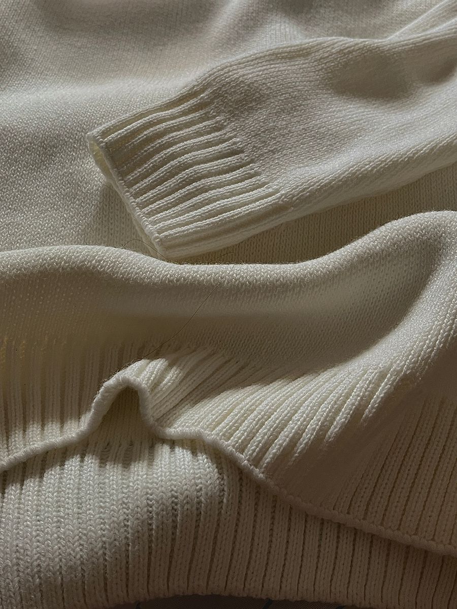 Close-up of a cream ribbed wool jumper showing the knit texture