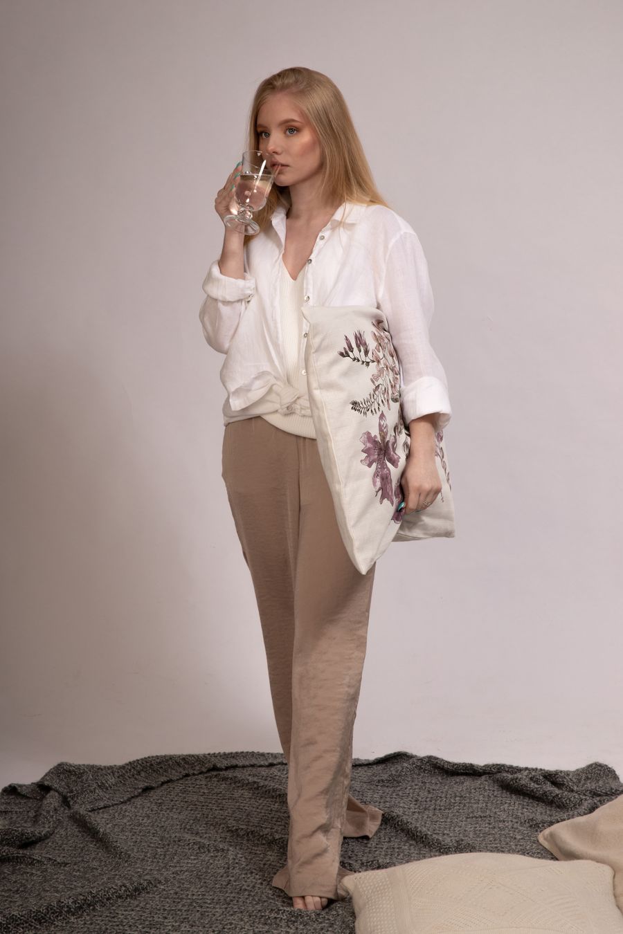 Woman in wide oat-coloured linen trousers and a white shirt